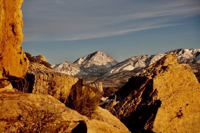 Sunlit sandstone rocks framing snow-covered peaks, Canyon of the Ancients Ranch, Montezuma County, Colorado