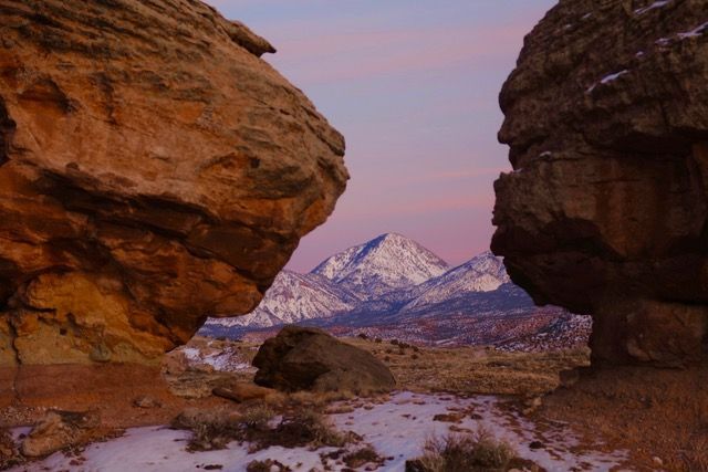 Large boulders frame a snowy peak under an evening sky, Canyon of the Ancients Ranch, Montezuma County, Colorado