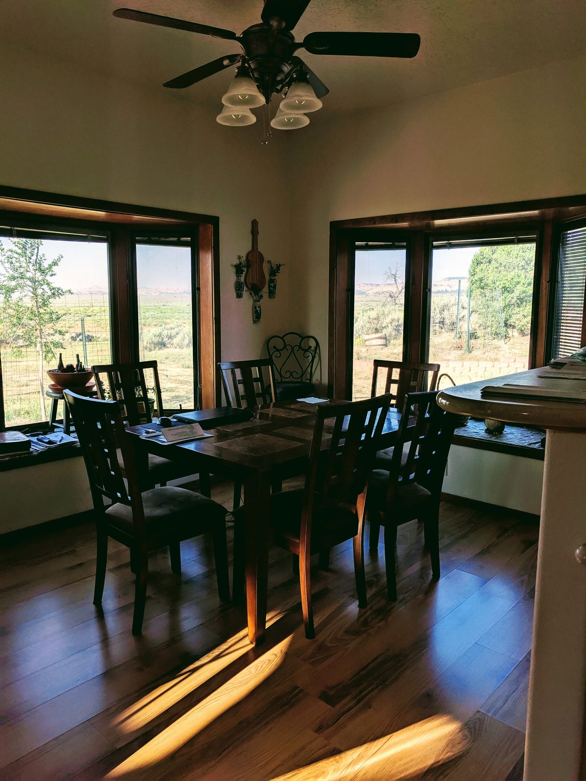Dining room with corner windows looking out on the land at Casa Blanca, Rio Arriba County, New Mexico