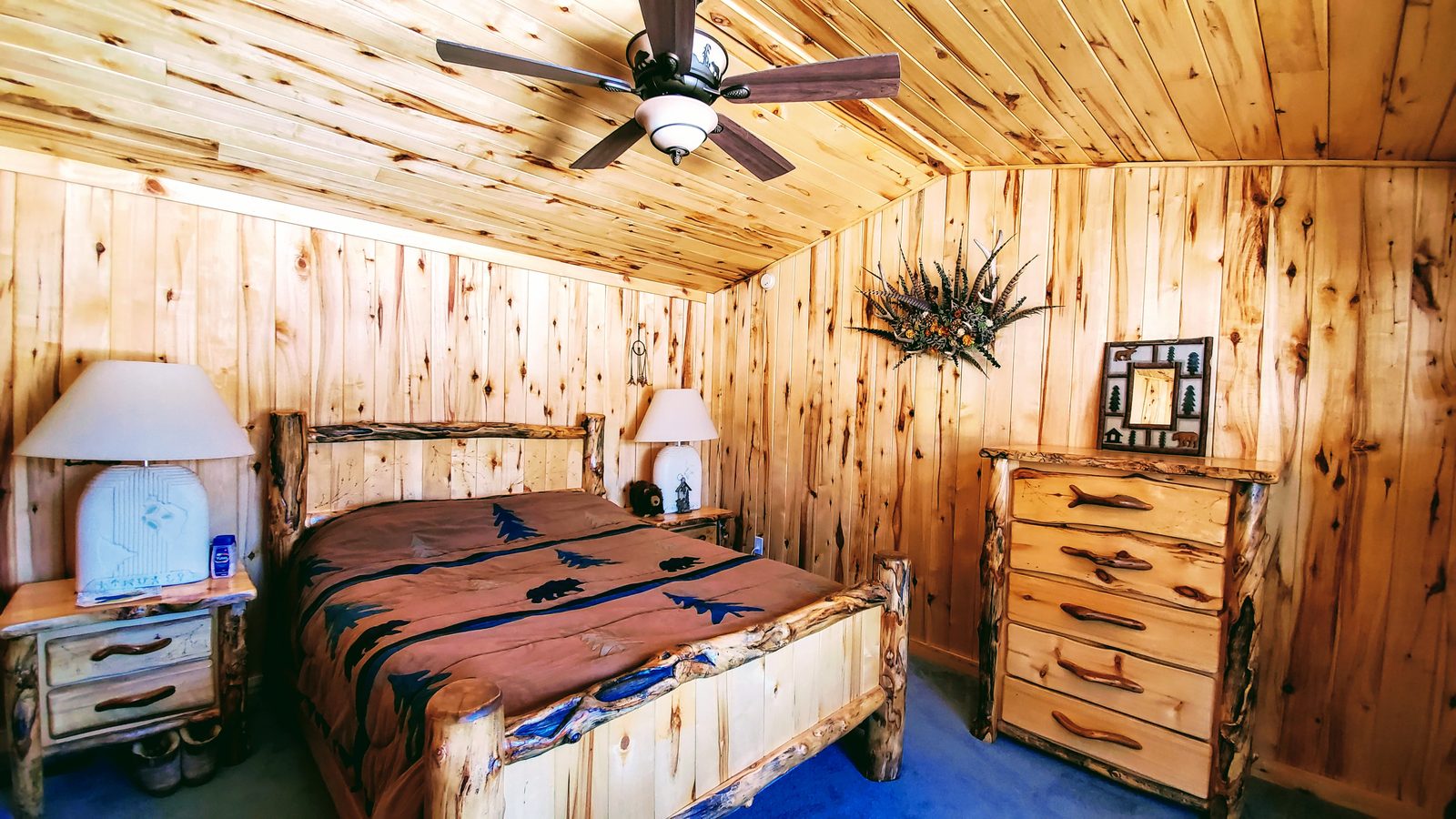 Bedroom with knotty-pine walls and a log bed frame at Horse Creek Ranch, Lake George, Teller County, Colorado