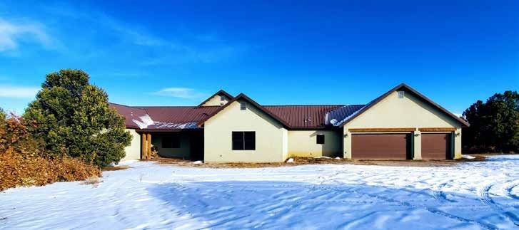 House with a metal roof in the snow at Los Piñones Ranch, Rio Arriba County, New Mexico