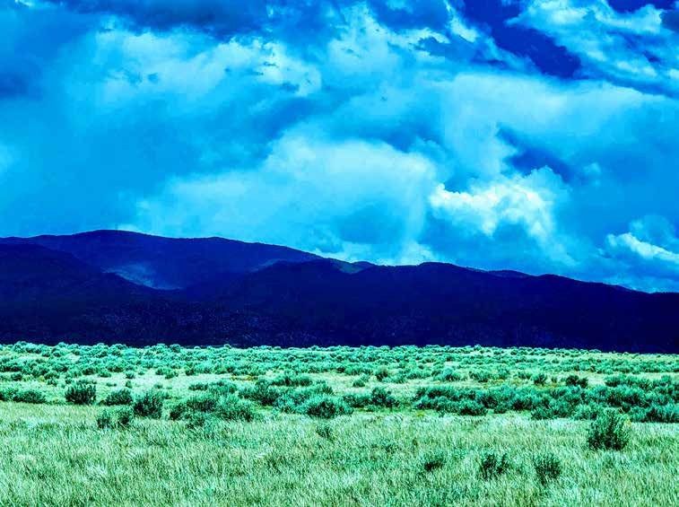 Open pasture and dark mountains at Taos Enchanted Valley, Taos County, New Mexico